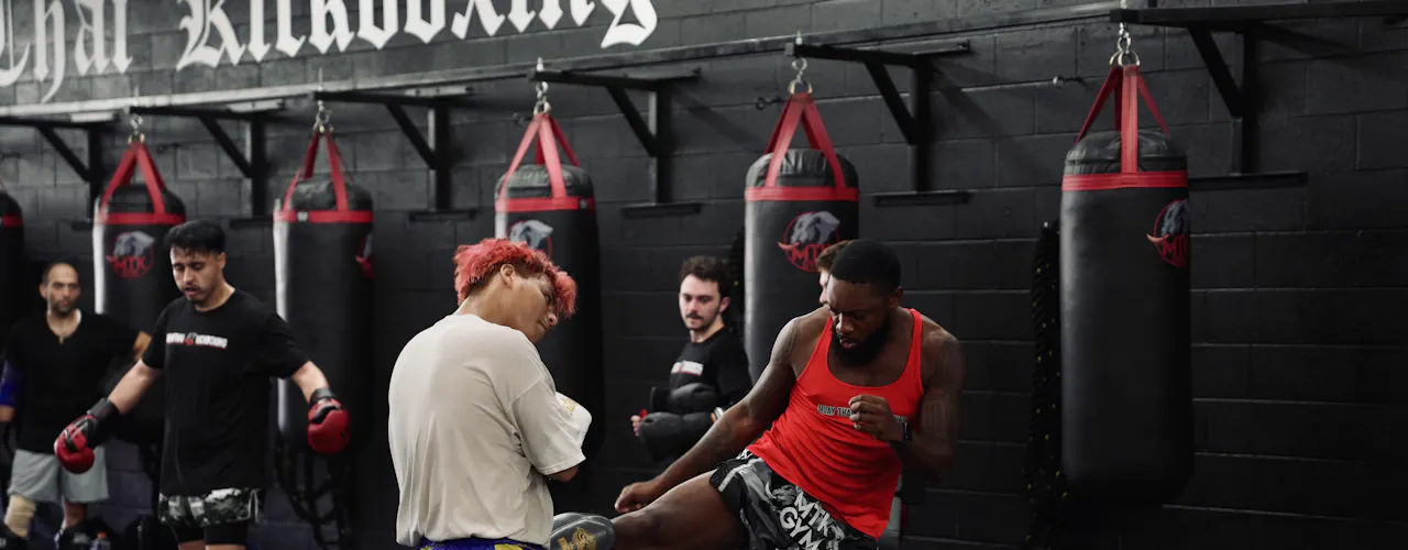 People training among punching bags in a gym