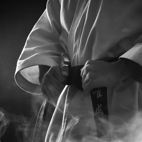 A martial artist tightening a black belt